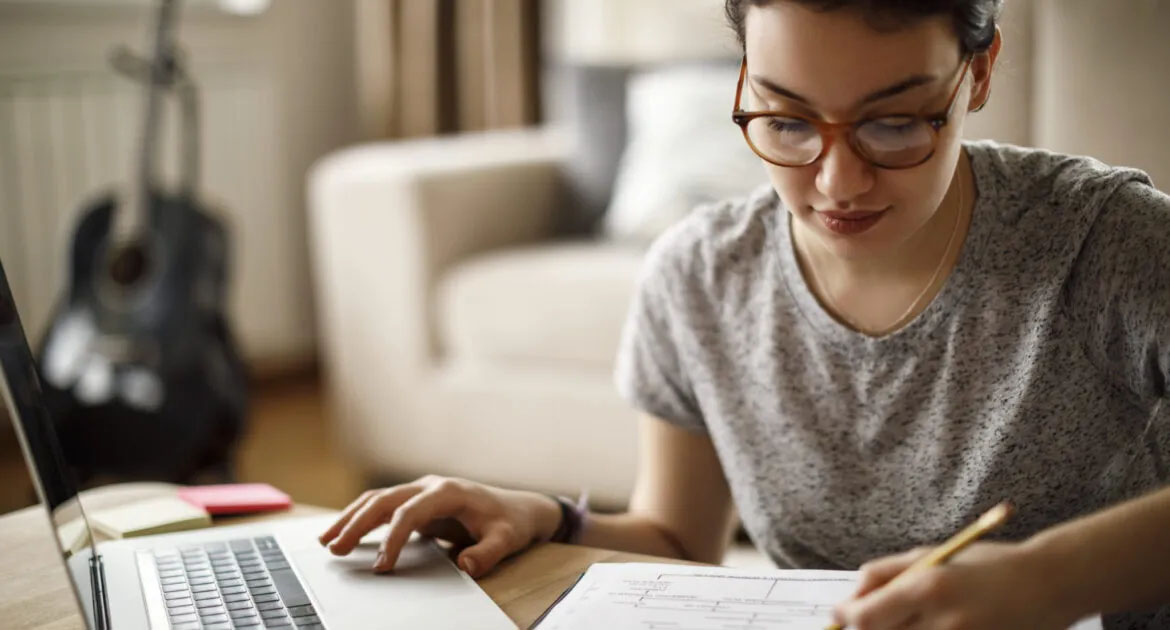 Woman working on a computer and making notes