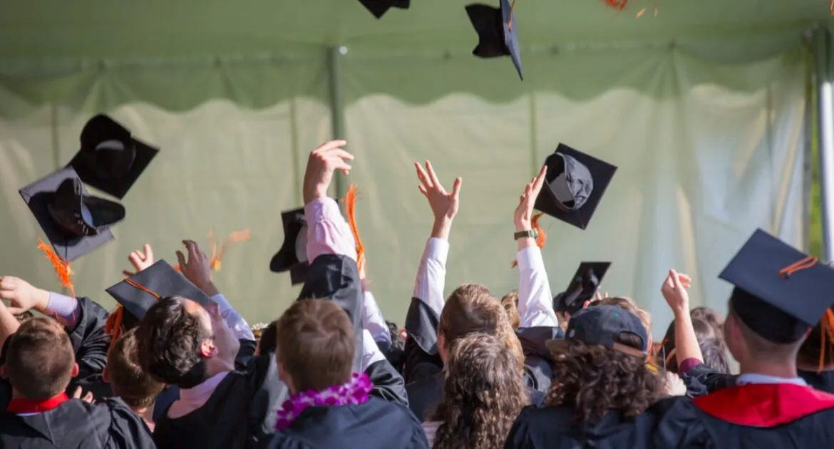 A group of people throwing graduation caps